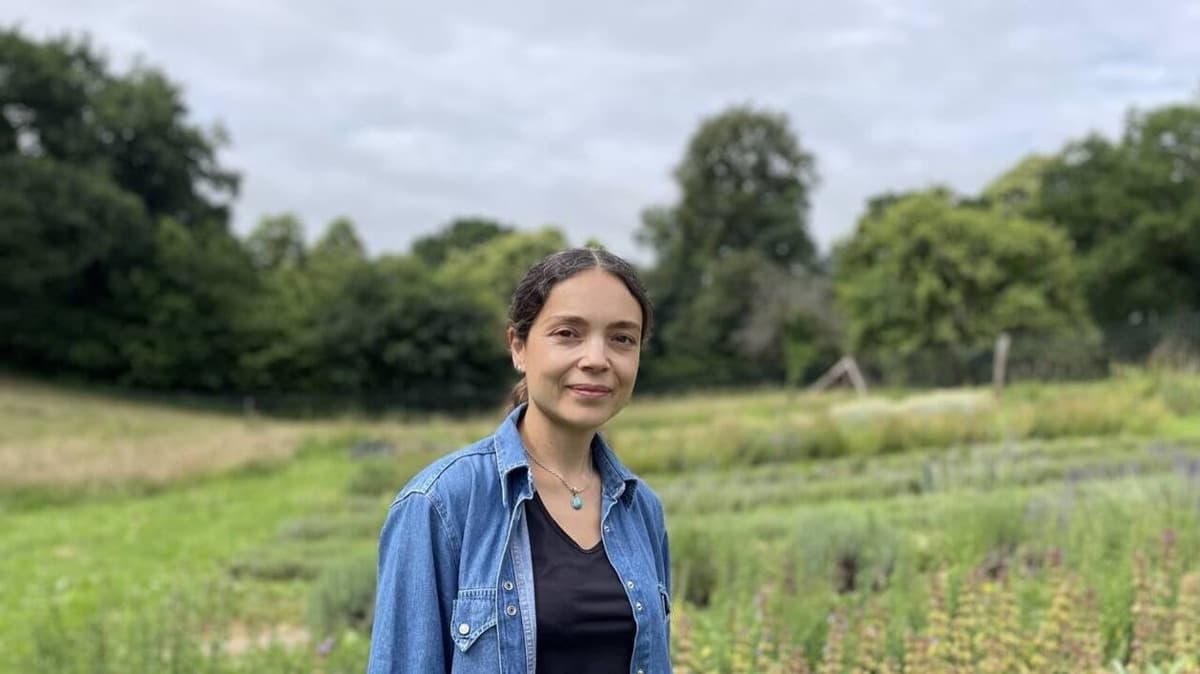 Alexandra Chennevière dans le jardin de Bonvouloir, les rangs de plantes derrière elle